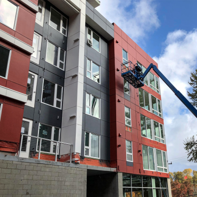 Worker on construction lift at Mt. Baker Station Apartments building